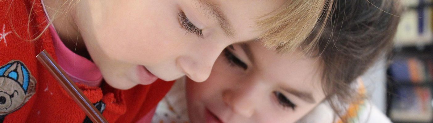 Zwei Mädchen sitzen am Schreibtisch